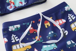 Dettaglio dei pantaloncini da nuoto blu navy per bambini con stampe di auto e coulisse