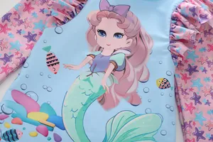 Detail of girls long sleeve swimsuit featuring mermaid print and ruffled side seams