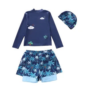 Detailed flat lay of three-piece kids swimwear with long sleeve top and palm print shorts