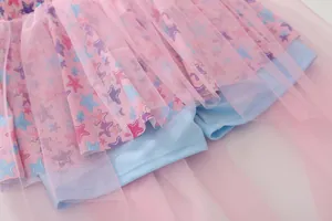 Detail of pink mesh tutu skirt layers over blue lining with colorful star print