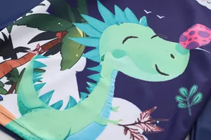 Close-up of boys blue swimwear fabric with cartoon dinosaur print and flatlock stitching