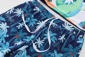 Detail of children's swimwear featuring palm tree prints and functional waist drawstring