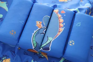 Dettaglio del giubbotto da nuoto blu con blocchi di galleggiamento e stampe di dinosauri
