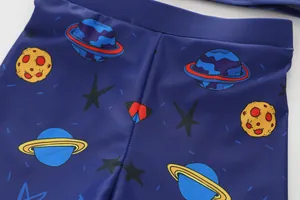 Close-up of boys swimwear featuring blue planets and yellow moon cartoon pattern
