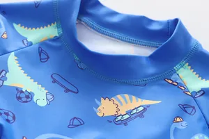 Dettaglio del girocollo e delle cuciture del costume da bagno blu con dinosauri per bambini