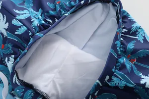 Close-up of boys' swim shorts featuring tropical prints and breathable white mesh lining