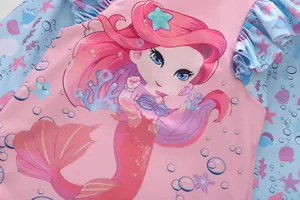 Close-up of pink girls' swimsuit with mermaid print and ruffled ocean details