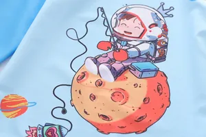 Close-up of boys swimwear featuring a cute cartoon astronaut print on blue fabric