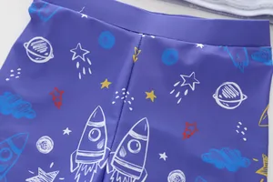 Close-up of kids swimwear fabric featuring a detailed space rocket and planet print