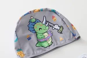 Dettaglio della cuffia da nuoto per bambini con motivi di dinosauri e animali grigi