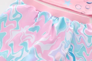 Detail van zwembroekje met roze en blauwe marmerprint en elastische geplooide tailleband