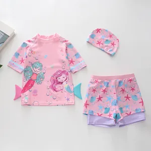 Dettaglio flat lay del costume da bagno tre pezzi a sirena per bambina con cuffia