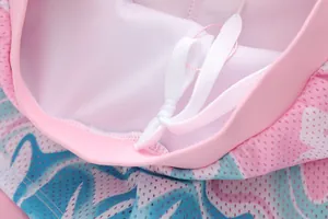 Detail of pink floral mesh fabric on girls' mermaid swimsuit with white drawstring
