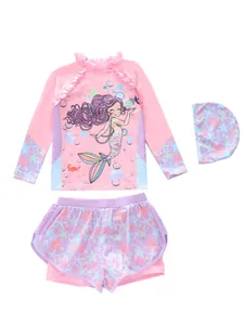 Detailed flat lay of girl's three-piece mermaid swimsuit with top, shorts, and swim cap