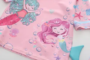 Dettaglio del costume da bagno rosa a maniche lunghe con stampe di sirene e cuciture curate
