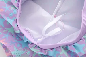 Detail van meisjes zeemeermin badpak met zeesterrenprint en ademende mesh voering