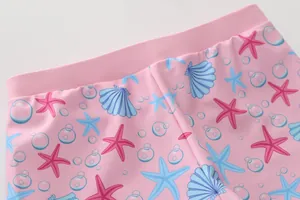 Dettaglio del costume da sirena rosa con vita elastica e motivi di conchiglie