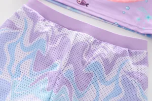 Detailed macro view of girls mermaid swim shorts featuring breathable mesh and ruffles