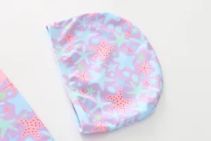 Detail of lavender kids swim cap with colorful starfish and shell pattern for swimming