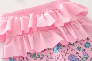 Détail de maillot de bain rose pour filles avec volants superposés et imprimé floral