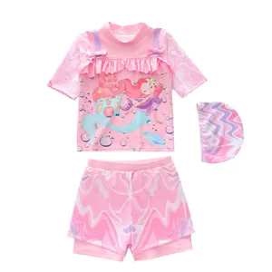 Three-piece girls mermaid swimsuit set with pink ruffled top, bottoms, and swim cap