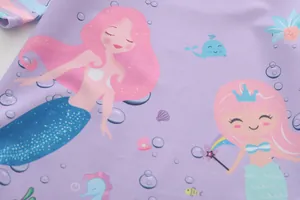 Dettaglio del tessuto per costumi viola con sirene e creature marine a fumetti