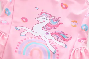 Close-up of pink girls swimsuit featuring a colorful unicorn and rainbow print with ruffles