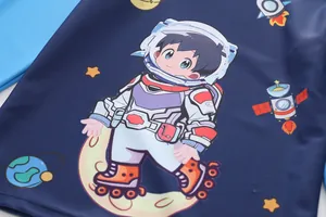 Detail of boys navy blue swimwear featuring a cartoon astronaut and space themed print