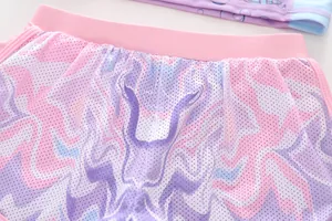 Close-up of pink and purple flame print mesh fabric with elastic waistband on girls' swimwear