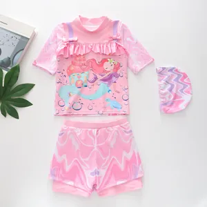 Detailed flat lay of pink three-piece mermaid girls swimsuit with ruffles and bow
