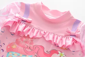 Close-up of pink mermaid swimsuit detail with ruffled collar and cute bow accents