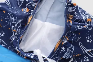 Close-up of boys swim trunks with space print, mesh lining and white drawstring waist