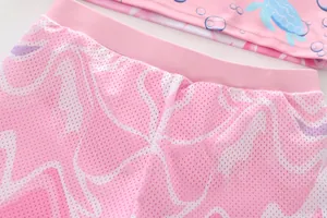 Close-up of pink breathable mesh fabric and elastic waistband on girls mermaid swimwear
