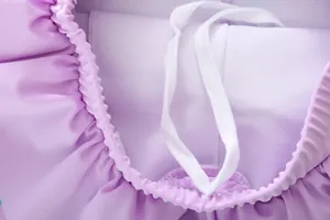 Détail du bord à volants violets et du cordon ajustable sur le maillot de bain