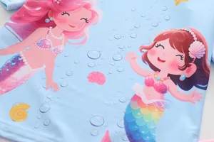 Dettaglio del costume da bagno celeste per bambine con stampe a sirena e conchiglie
