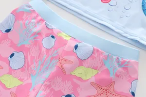 Dettaglio della stampa a sirena e conchiglie rosa sul costume da bagno per bambini