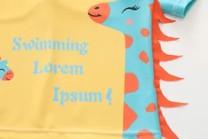 Dettaglio di costume da bagno per bambini con stampa dinosauro e pinne 3D arancioni