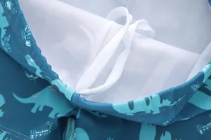 Detail der Kinder-Badeshorts mit Dinosaurier-Print, Kordelzug und weißem Netzfutter