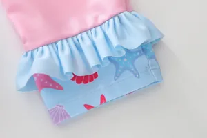 Detail of ruffled hem and nautical prints on pink and blue girls' two-piece swimwear