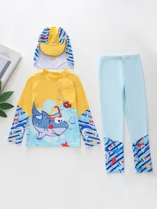 Flat lay of kids long sleeve rash guard set with shark print and sun protection hat