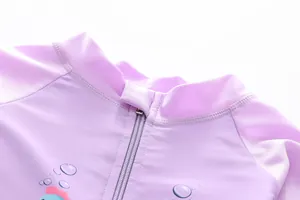 Detail of girls purple swimsuit featuring a protective zipper guard and stand-up collar