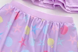 Close-up of purple girls swimming skirt with elastic waist and sea shell starfish patterns