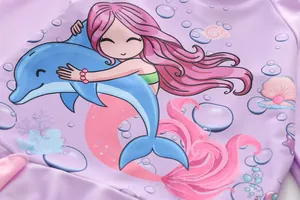 Détail de l'imprimé sirène et dauphin sur le tissu du maillot de bain fille violet