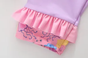Detail of girls swimwear featuring purple fabric, pink ruffles, and jellyfish print