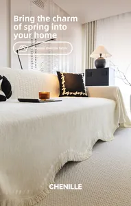 Détail de la housse de canapé en chenille crème avec pompons et tissage texturé élégant