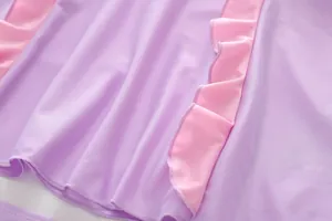 Vue détaillée du volant rose et du tissu extensible violet clair sur le maillot de fille