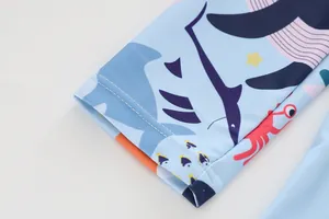Detail shot of blue kids' swimsuit sleeve with cartoon ocean print and durable stitching