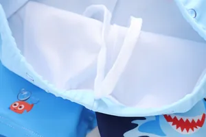 Dettaglio dei pantaloncini da nuoto blu da bambino con stampa squalo e fodera a rete