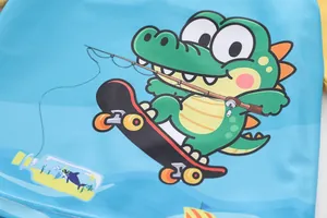 Nahaufnahme der blauen Kinderbadebekleidung mit Cartoon-Krokodil-Motiv auf Skateboard