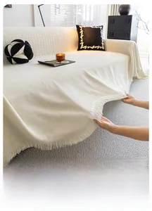 Détail de la housse de canapé en chenille blanc cassé avec texture tissée et franges